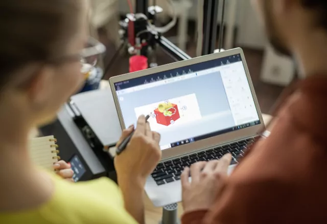 people looking at a 3d model on a laptop