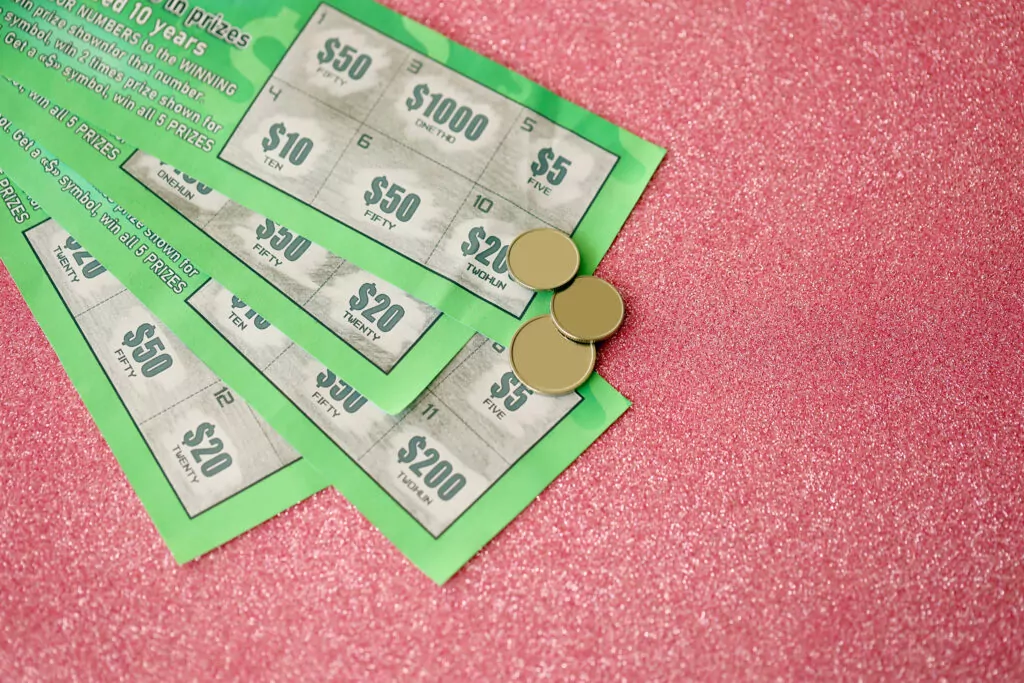 Scratch and win cards with coins on pink glitter background promoting prize incentives